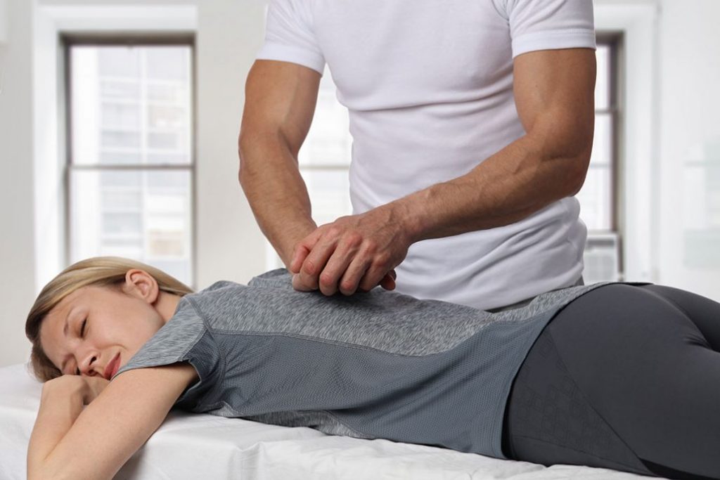 Woman having chiropractic back adjustment